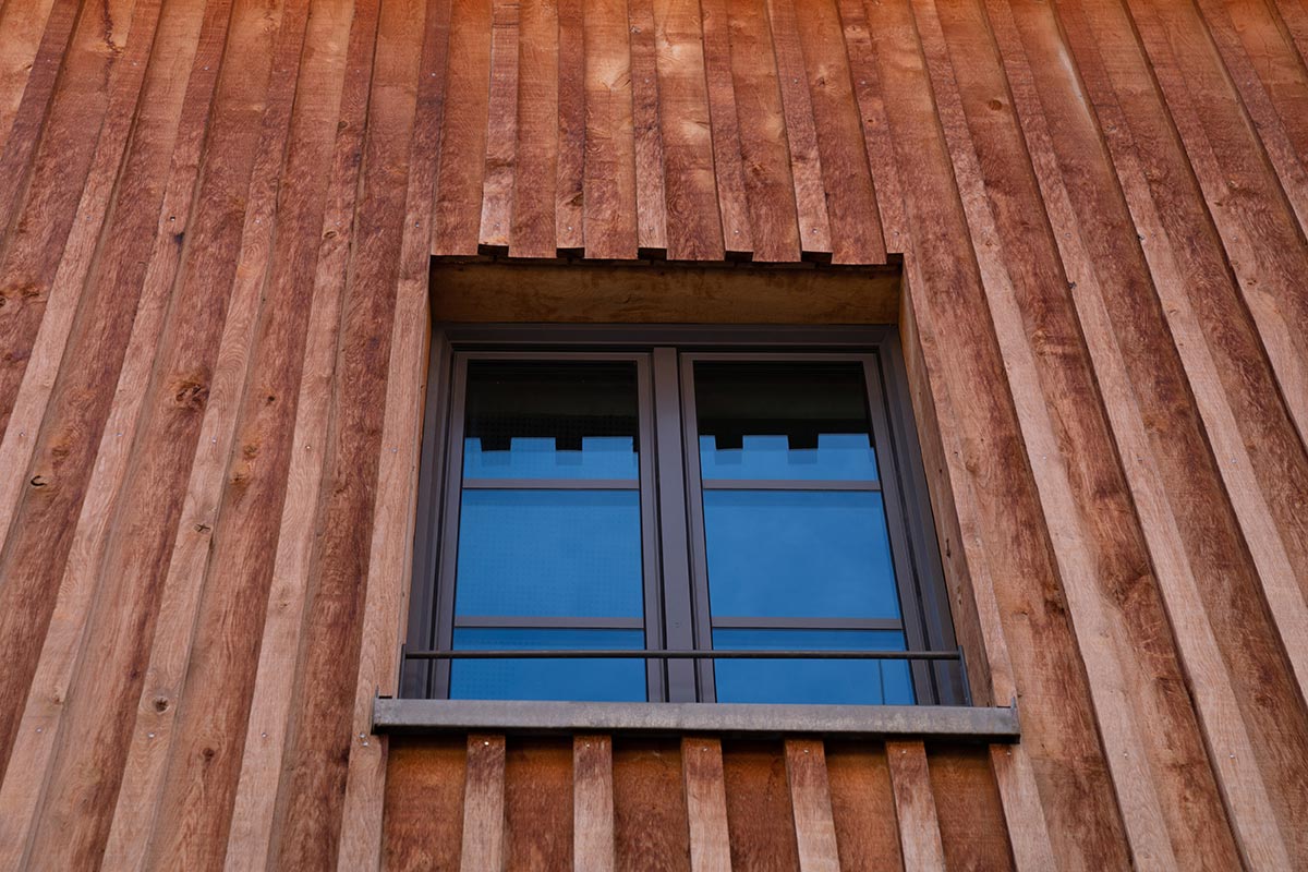 Gebäude mit moderner Bodendeckelschalung Gebäude mit Holzfassade in Bodendeckelschalung.